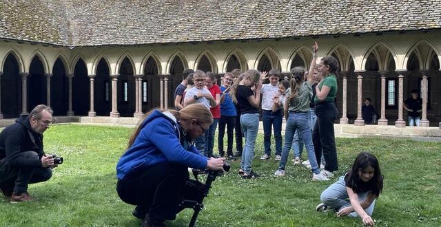 photo les enfants de précey en train de faire le clip dans le cloître de l’abbaye du mont-saint-michel. 